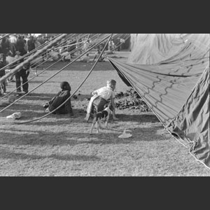 Two little negro boys sitting looking in tent Ringling Bros