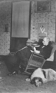 Papa in front room reading with Laddie Boy on the floor