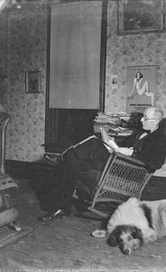 Papa in front room reading with Laddie Boy on the floor