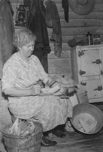 Aunt Minnie shucking Roast'n ears on back porch