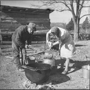 Ruth N_ Claudis squeezing out lard at rendering pot - Thanksgiving